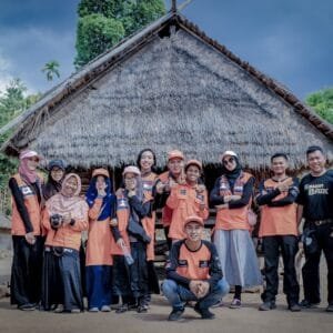 group of people standing near brown wooden house